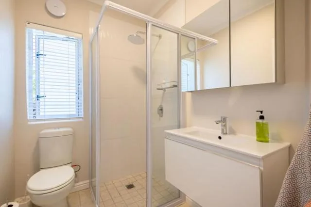 Clean modern bathroom with shower enclosure, vanity, and toilet
