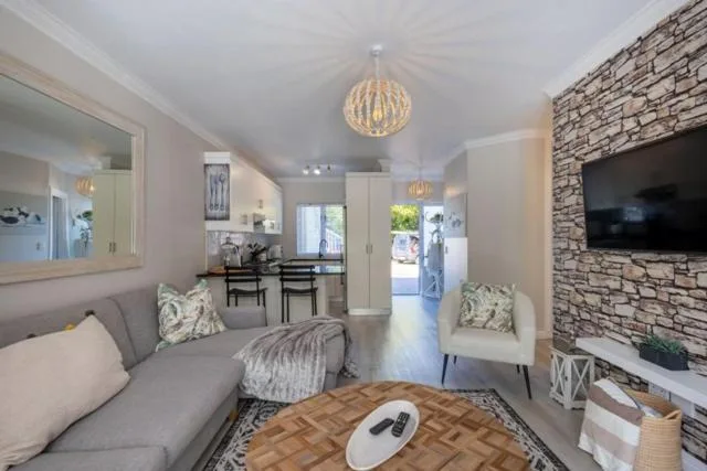 Modern lounge with grey sofa, stone fireplace, and pendant lighting