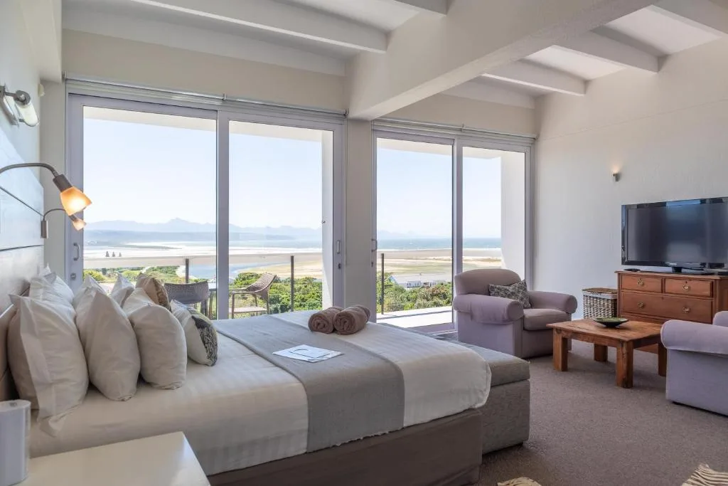 Spacious bedroom with ocean and lagoon views through sliding glass doors