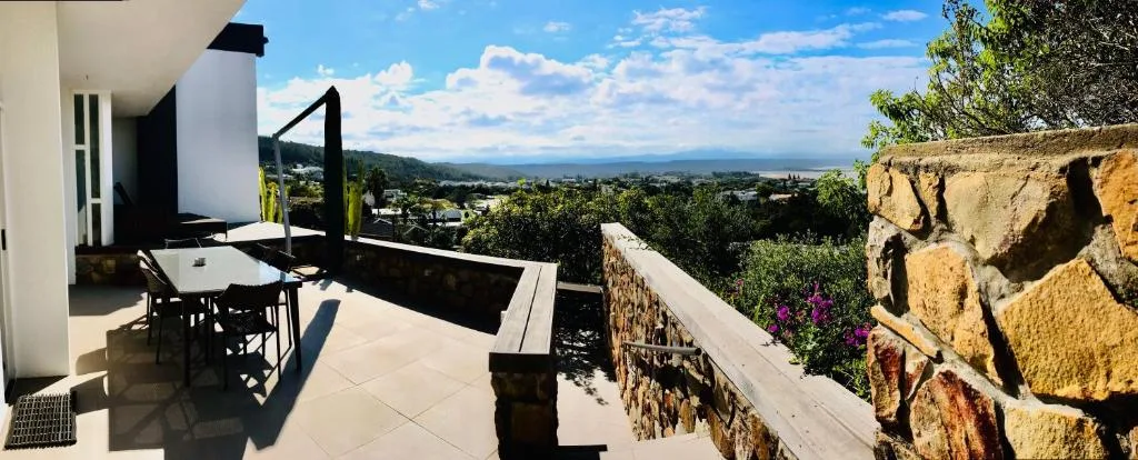 Spacious outdoor deck with dining table overlooking scenic valley and mountains