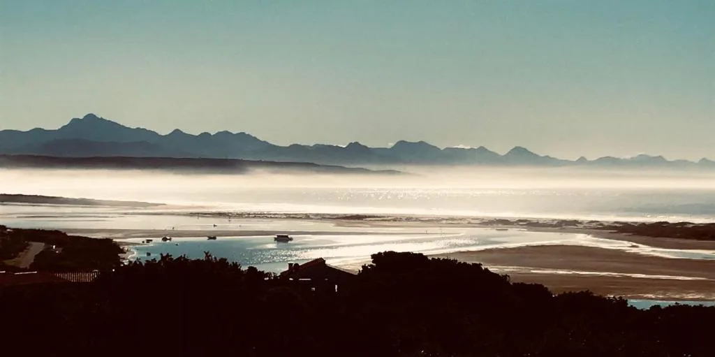 Panoramic coastal vista with mountains, bay, and morning mist over Plettenberg Bay