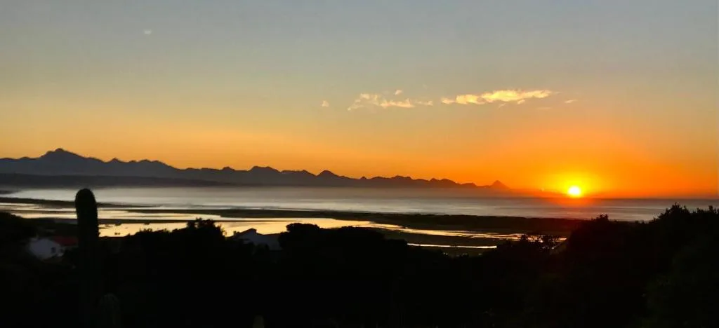 Golden sunset over mountain range and lagoon waters at dusk