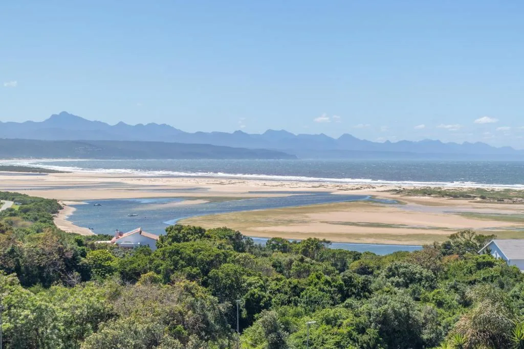 Panoramic coastal vista showing lagoon, beach, and mountain range on horizon