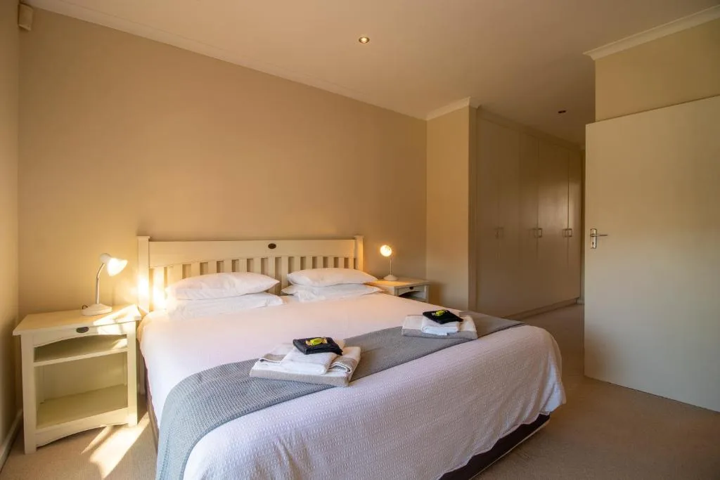 Spacious bedroom with double bed, bedside lamps, and built-in wardrobes