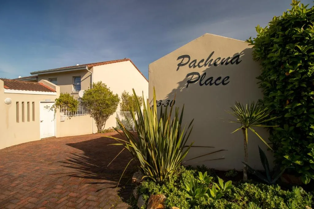Cream-colored modern building with Pachena Place signage and landscaped garden entrance