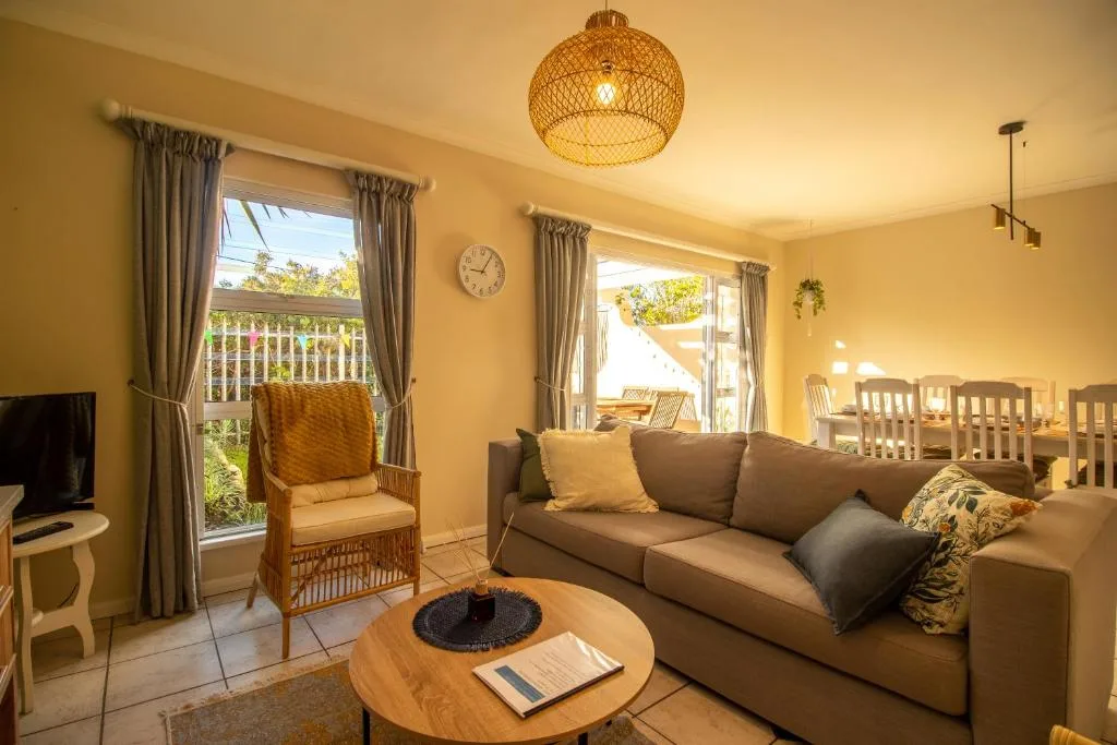 Bright yellow lounge with comfortable sofa, wicker chair, and open deck views