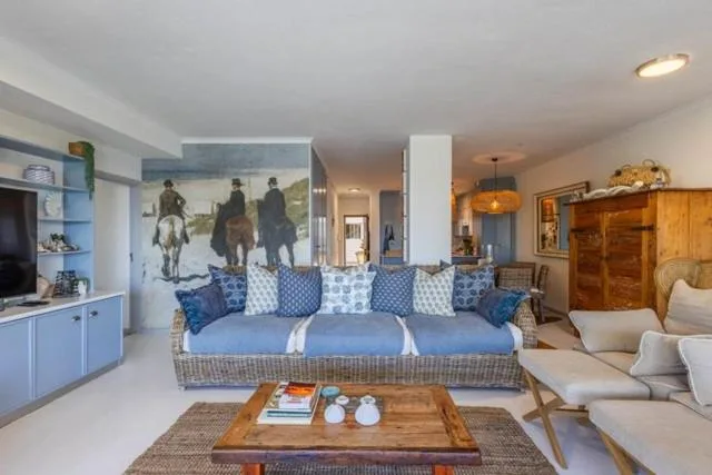 Open-plan living area with blue upholstered sofa and wooden coffee table
