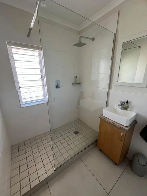Modern bathroom with walk-in shower, vanity sink, and mirror