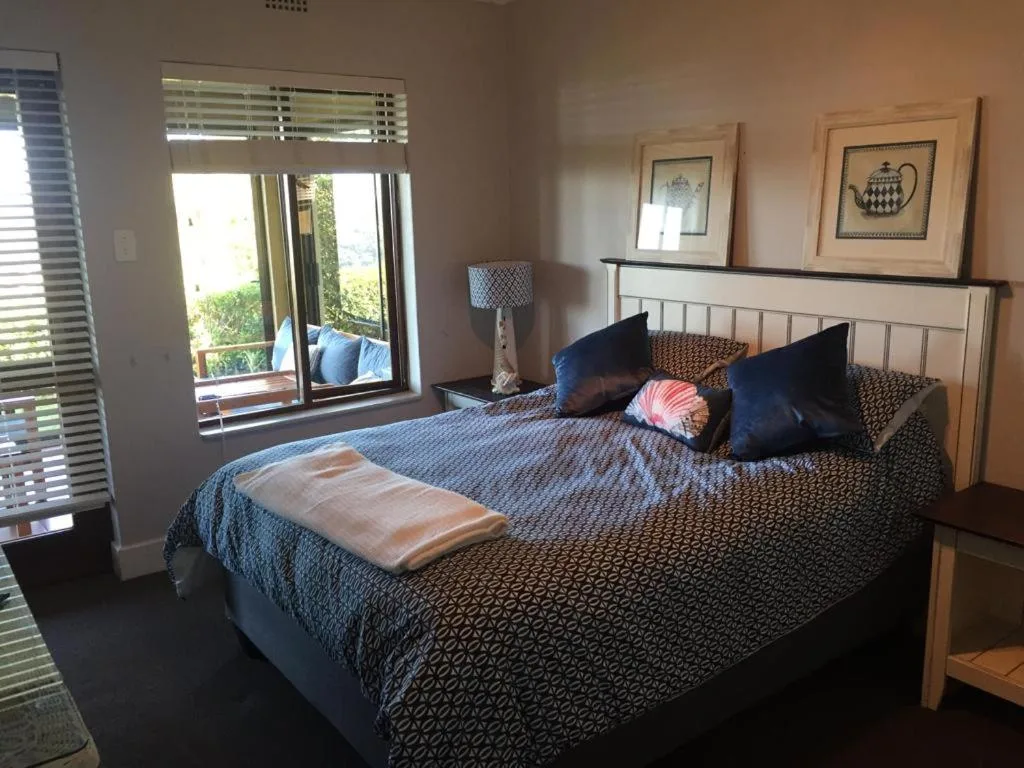 Spacious bedroom with queen bed, deck access, and decorative wall art