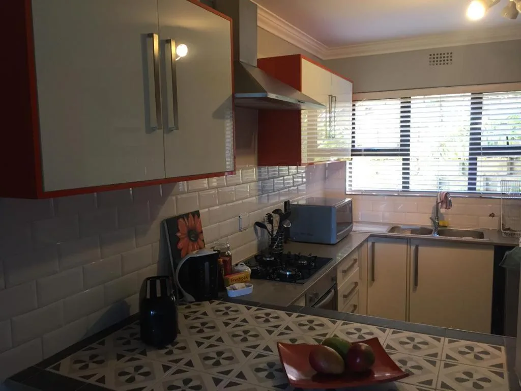 Modern kitchen with red cabinetry, gas stove, and subway tile backsplash