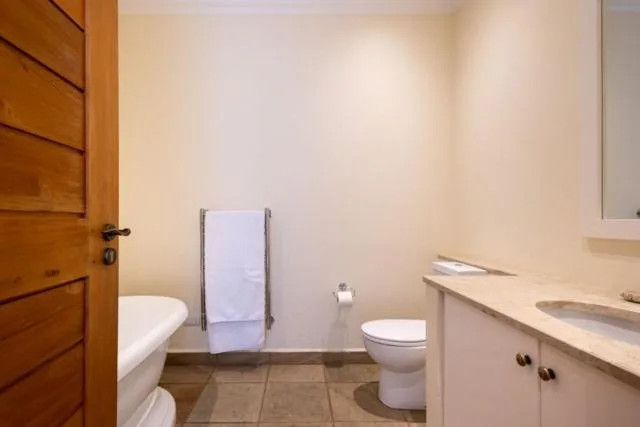 Modern bathroom with vanity, toilet, and towel rack