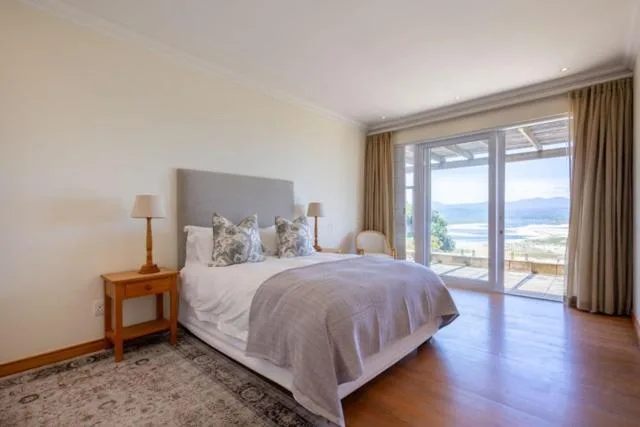 Bright bedroom with sea view through glass doors and windows