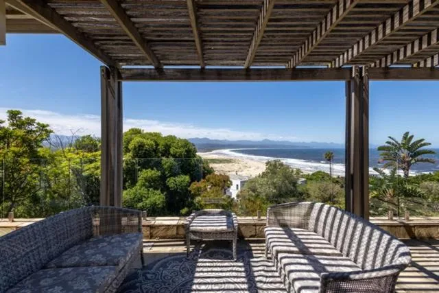 Shaded pergola deck with coastal views over beach and mountains