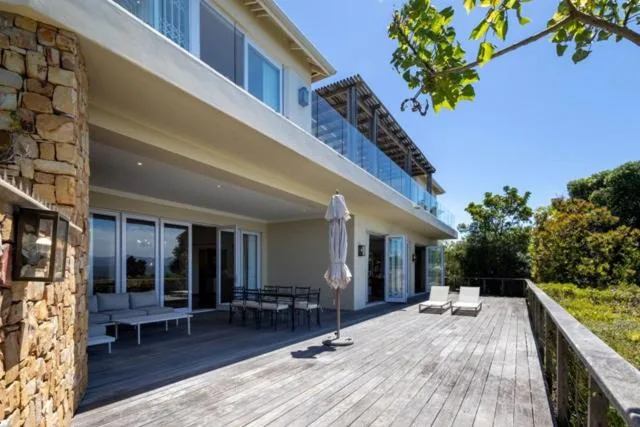 Wooden deck with outdoor seating and umbrella, modern white building facade