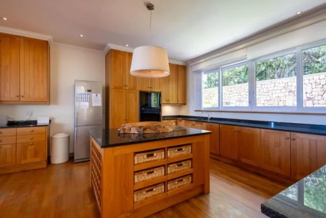 Spacious kitchen with wooden cabinetry, island bench, and large windows