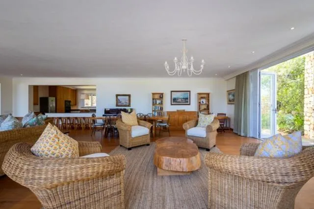 Spacious lounge with wicker armchairs, neutral furnishings, and garden views