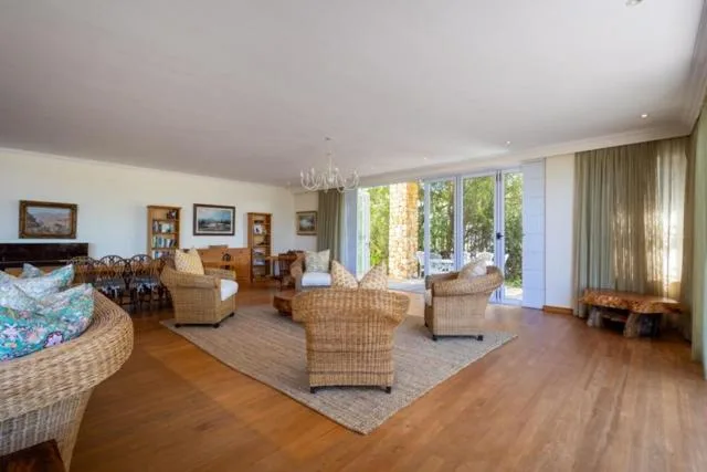 Spacious open-plan lounge with wicker furniture and garden views