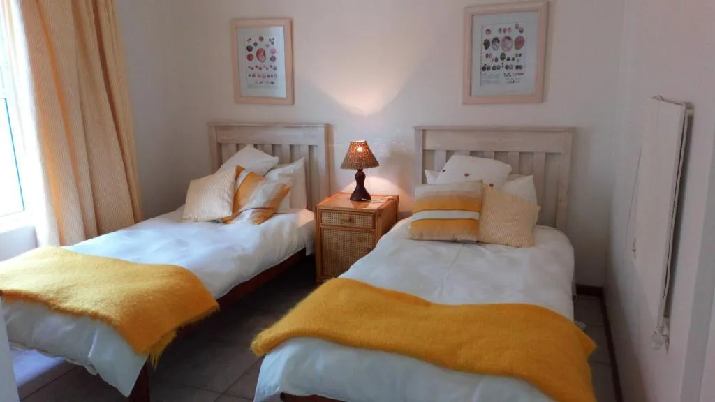 Twin bedroom with two single beds, wooden frames, and golden accents