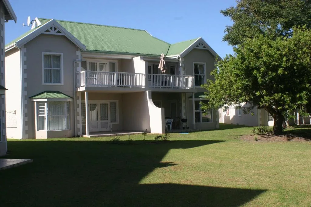 Modern two-story villa with green roof and manicured lawn frontage