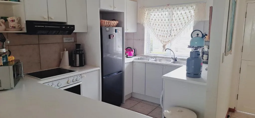 Well-equipped kitchen with white cabinetry, black appliances, and gas stove