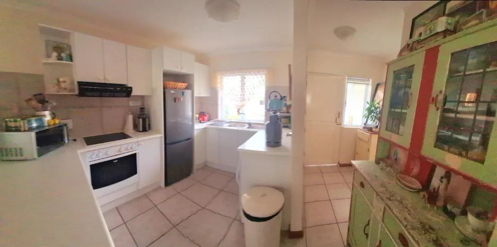 Bright kitchen with white cabinetry, black appliances, and central island