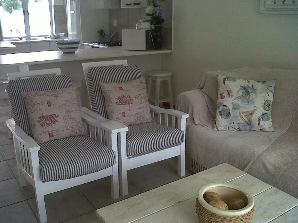 Bright lounge with striped armchairs, patterned pillows, and comfortable seating