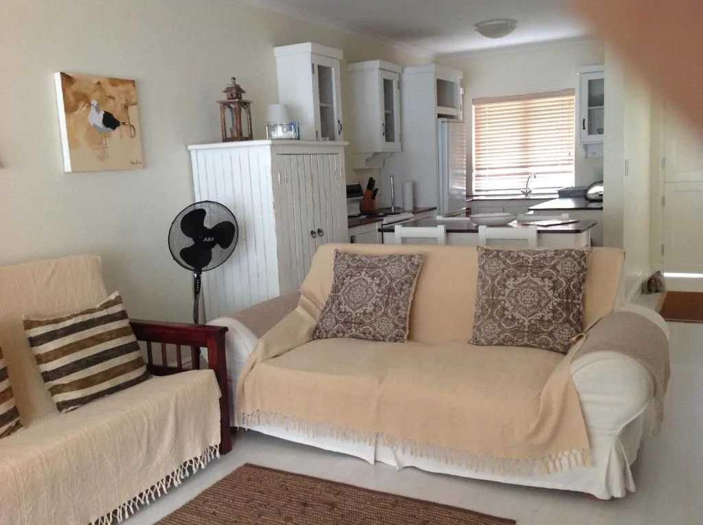 Cream-colored sofa with decorative pillows in open-plan living space