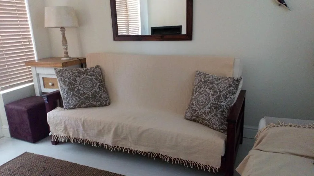 Cream sofa with patterned pillows and table lamp in bright living room