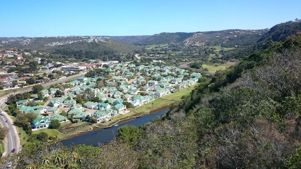 Aerial view of Riverclub residential estate with river, green hills, and mountains