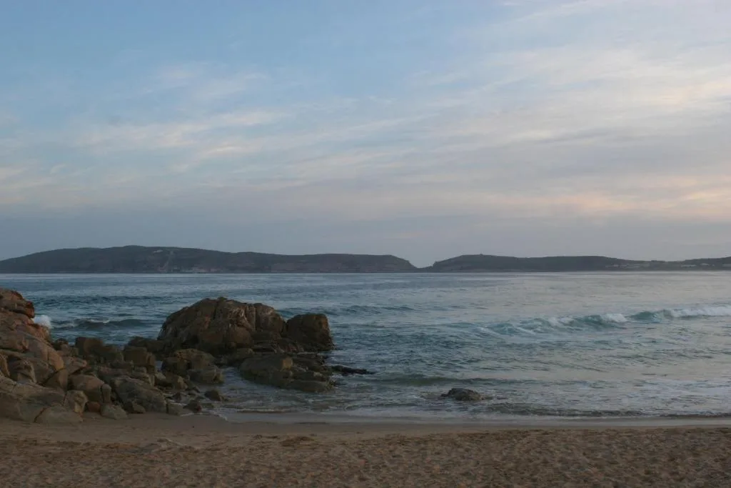 Scenic beach and ocean view with rocky outcrops and distant headlands