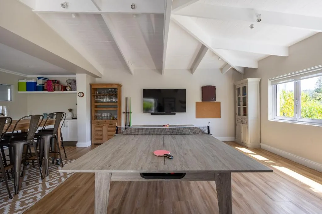 Spacious living room with ping pong table and wall-mounted television