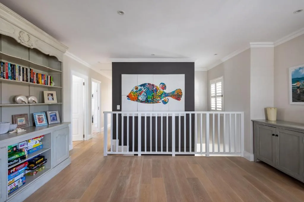Bright living room with colorful fish artwork and built-in shelving