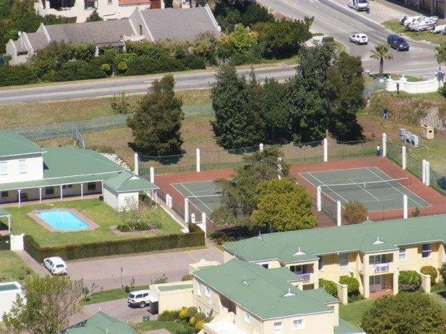 Aerial view of villa complex with pool, tennis courts and landscaped gardens