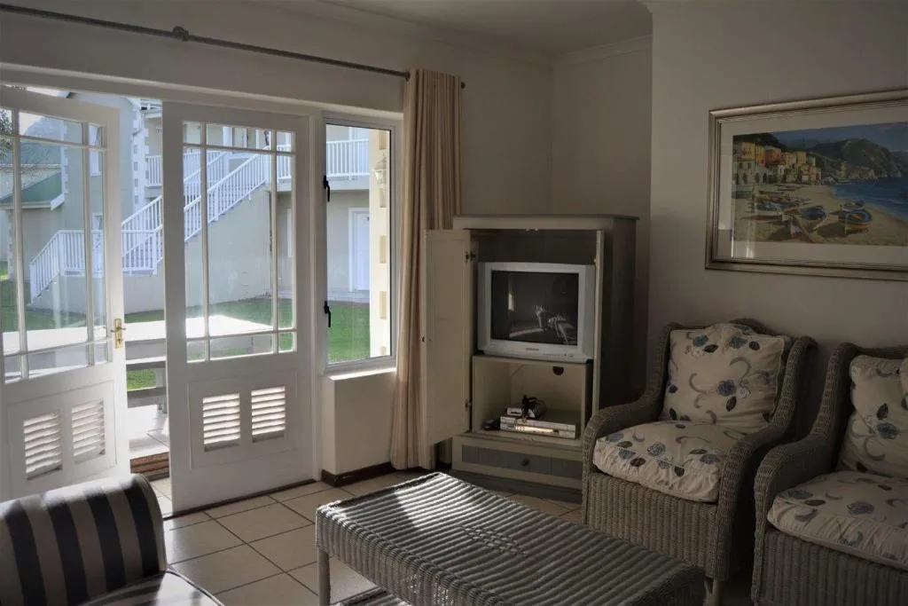 Bright lounge with fireplace, comfortable seating, and garden access doors