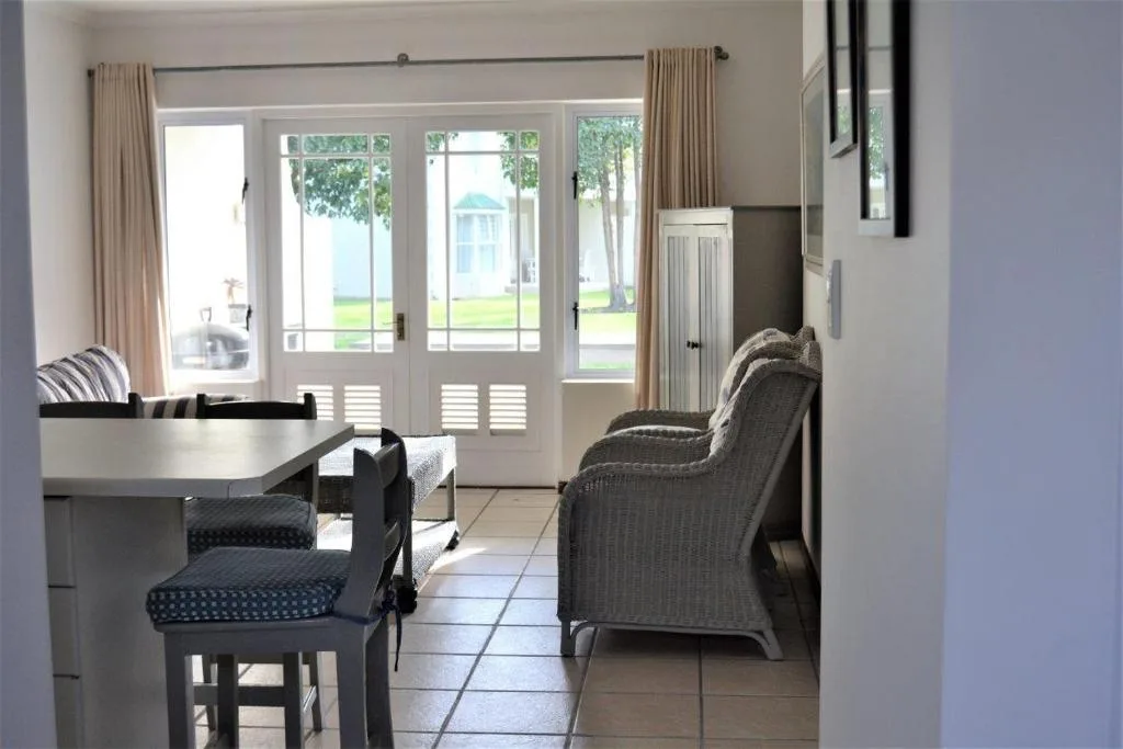 Bright lounge with comfortable seating and wide glass doors overlooking gardens