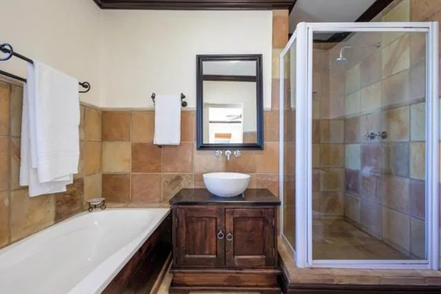 Spacious bathroom with bathtub, vanity sink, and walk-in shower enclosure