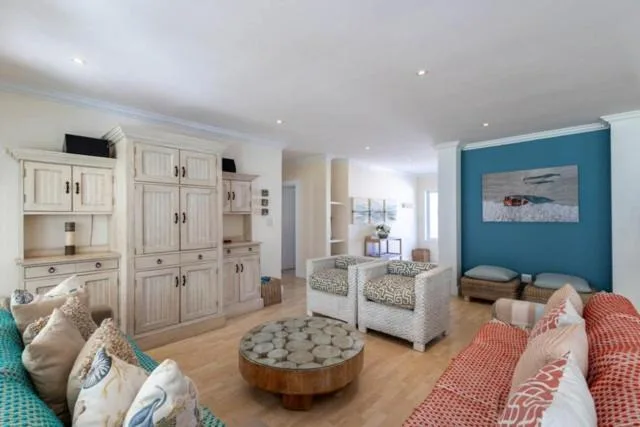 Spacious bedroom with twin beds, turquoise accent wall, and built-in cabinetry