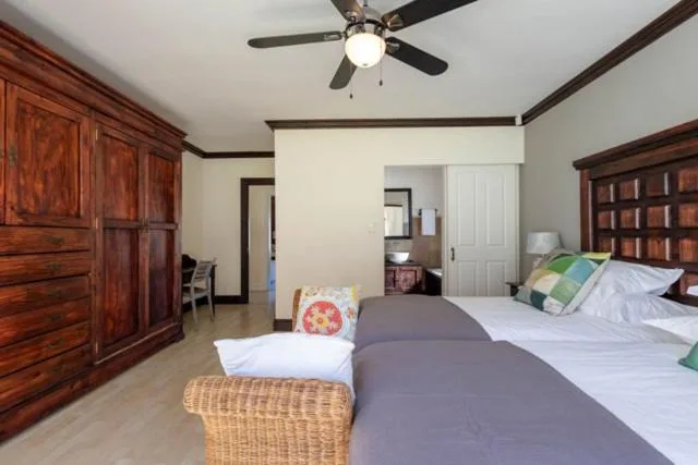 Spacious bedroom with twin beds, wooden cabinetry, and ceiling fan
