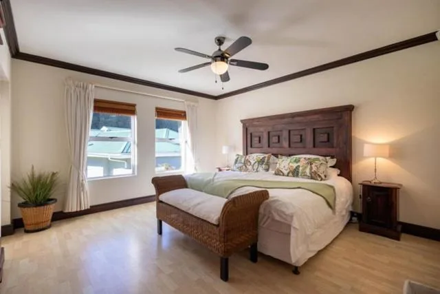 Spacious bedroom with wooden bed frame and ocean view windows
