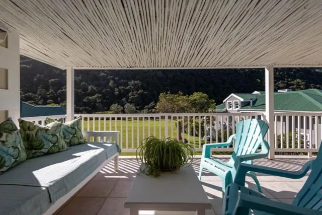 Spacious covered deck with seating, scenic lagoon and forest views beyond