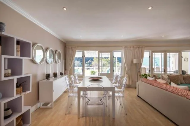 Modern dining area with table, chairs, and scenic mountain views through glass doors