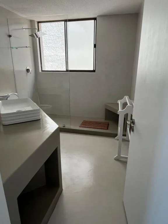 Modern bathroom with walk-in shower, vanity, and window
