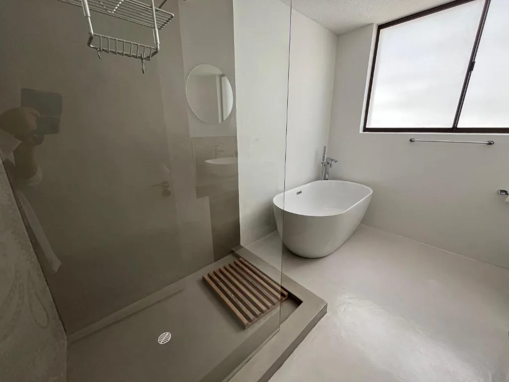 Modern bathroom with walk-in shower, freestanding tub, and circular mirror