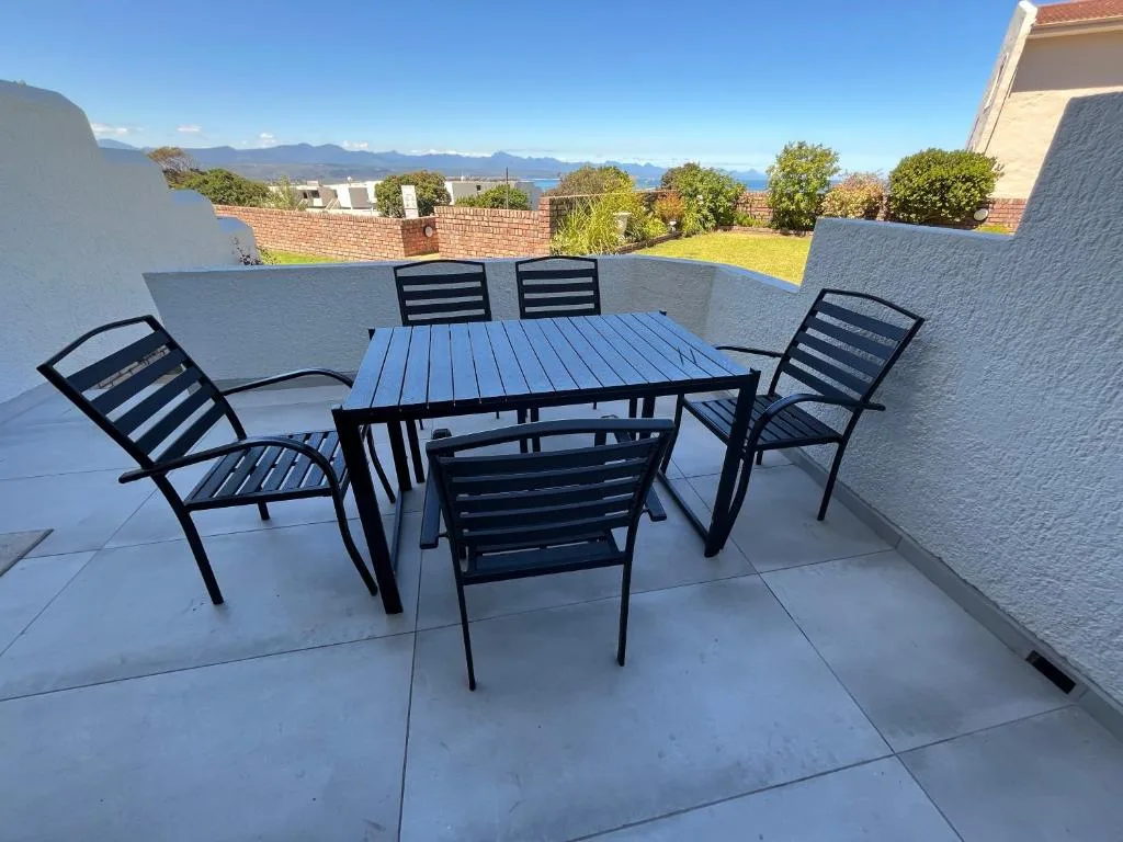 Modern patio with dining table and black chairs overlooking mountain views
