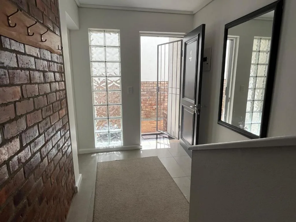 Modern interior hallway with brick accent wall and sliding glass doors