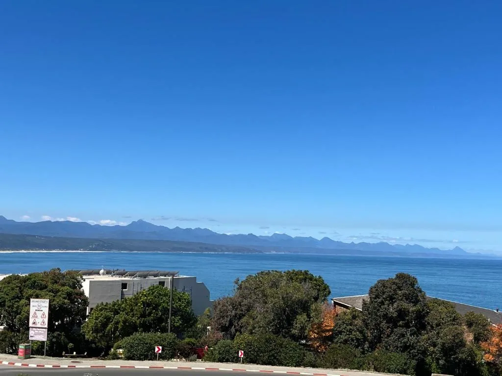 Scenic coastal vista with mountains, ocean, and sandy beach in distance