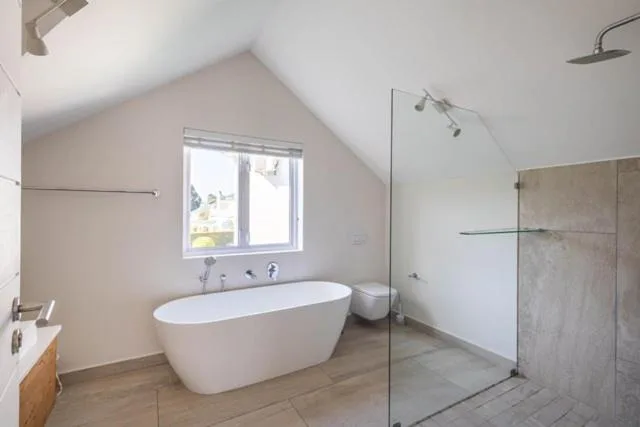 Modern bathroom with freestanding white bathtub and walk-in shower