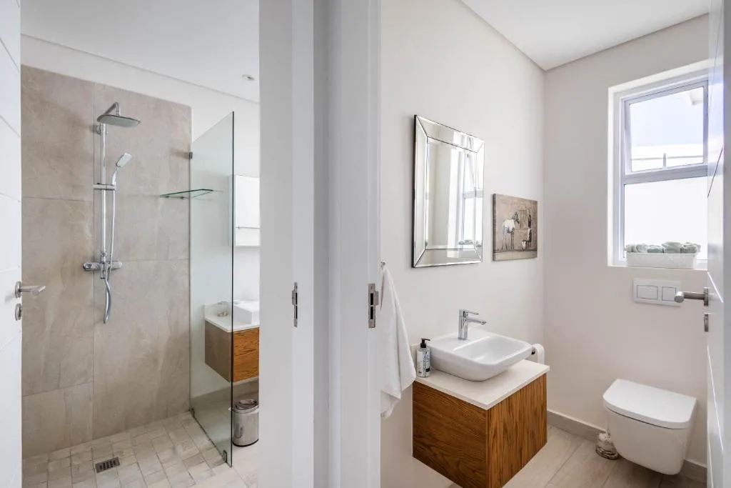 Modern bathroom with walk-in shower, vessel sink, and toilet