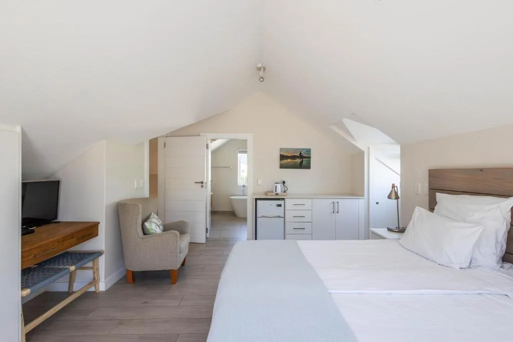 Spacious modern bedroom with bed, en-suite bathroom, kitchenette and lounge area