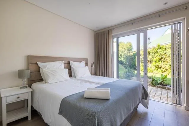 Spacious bedroom with queen bed, garden views through sliding doors